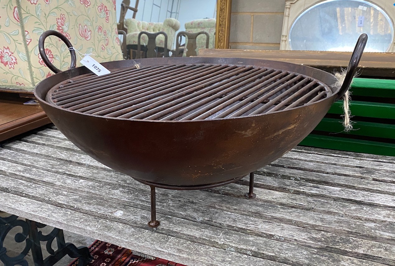 A circular wrought iron fire-pit on low stand, diameter 82cm, height 38cm